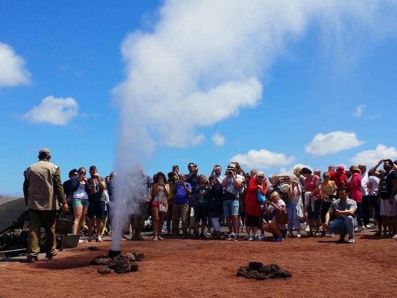 Gruppe Touristen, die in Timanfaya experimentieren