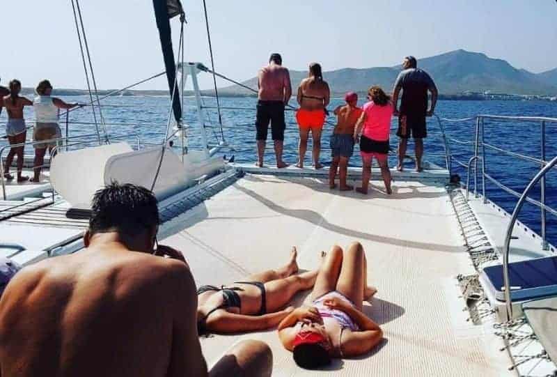 Turistas tomando el sol y disfrutando de la excursión en barco