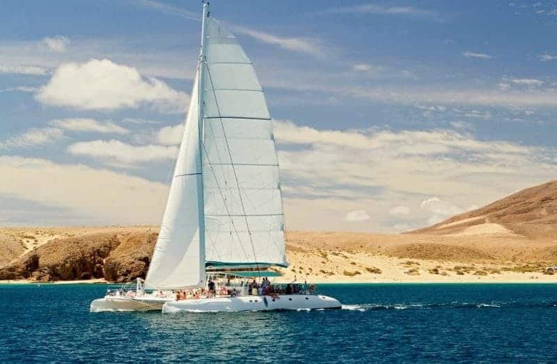 Catamarán con la vela izada frente a la Playa de Papagayo